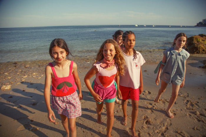 Girl wearing pink knitted top with straps and Cherry Print