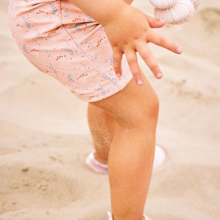 Baby Girl wearing Peach with Mimosa print swimsuit with matching swim shoes 