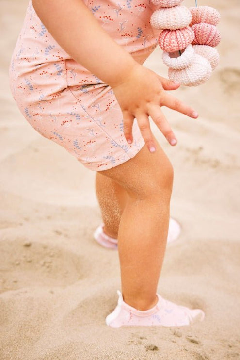 Baby Girl wearing Peach with Mimosa print swimsuit with matching swim shoes 