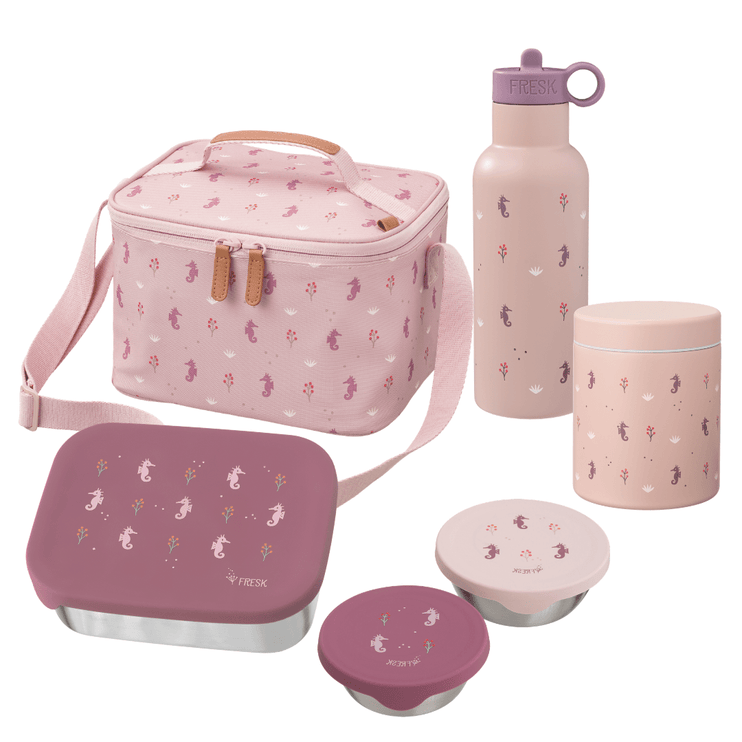 A coordinated reusable lunch set on a white background, including a pink patterned lunch bag, a pink bottle with a purple lid, a pink canister, a pink lunch box with a purple lid, and two small round containers.