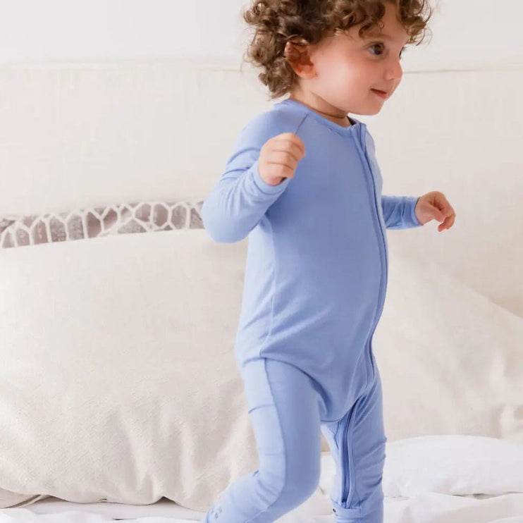 Child wearing a Bahry onesie standing.