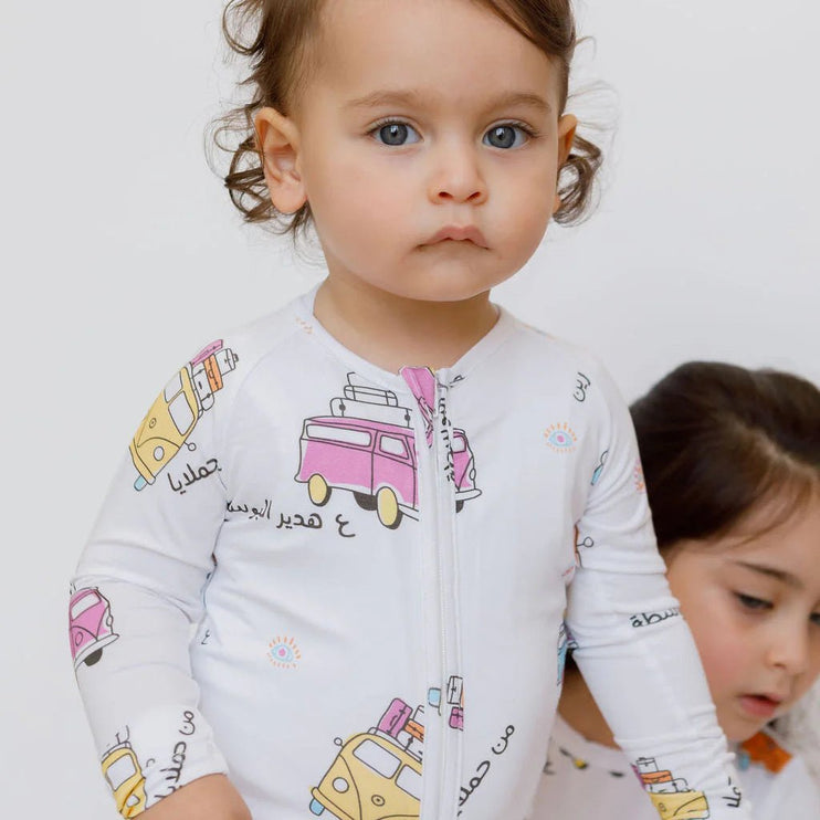 Two children wearing Bosta onesie with colorful vehicle prints.