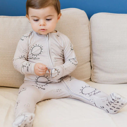 Child wearing a sobh onesie outfit with sun pattern