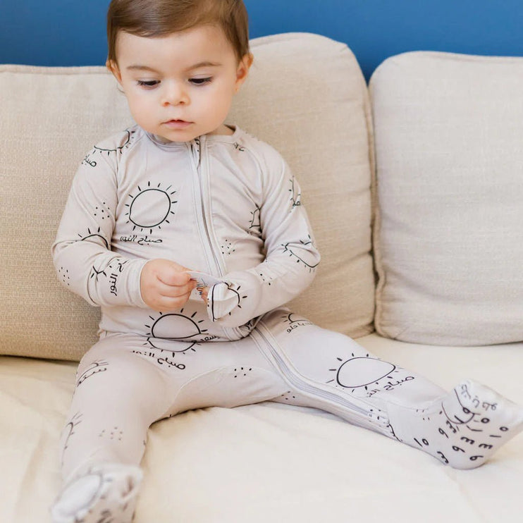 Child wearing a sobh onesie outfit with sun pattern