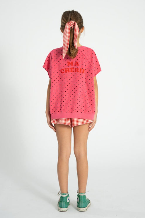 kid wearing pink sweatshirt with mini black hearts print