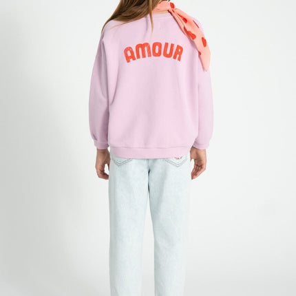 girl wearing lilac sweatshirt with print on the back