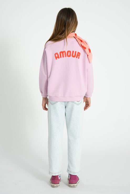 girl wearing lilac sweatshirt with print on the back