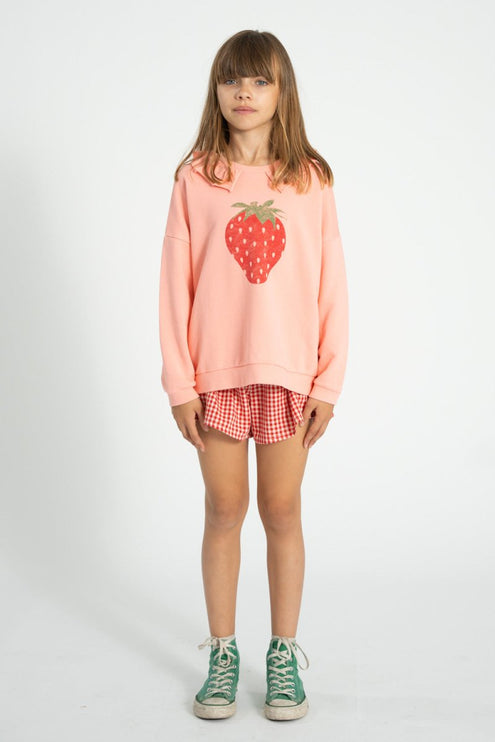 girl wearing a sweatshirt with collar and a red checkered shorts