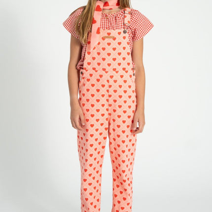 girl wearing a pink heart-patterned overall