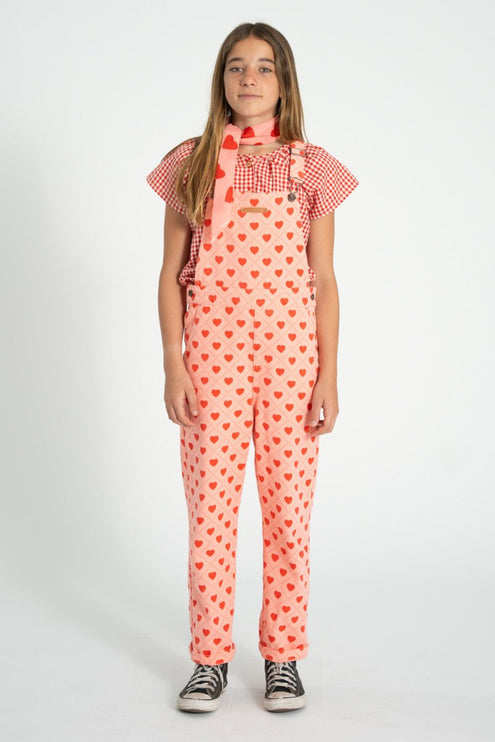girl wearing a pink heart-patterned overall