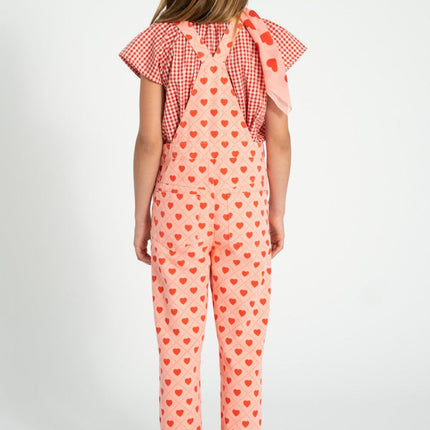 a girl wearing overall with hearts 