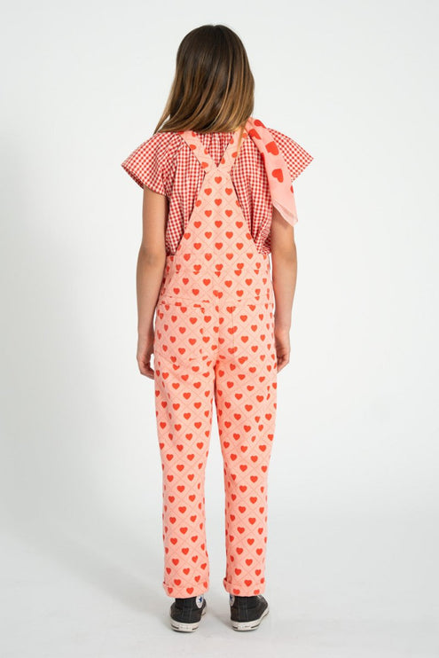 a girl wearing overall with hearts 