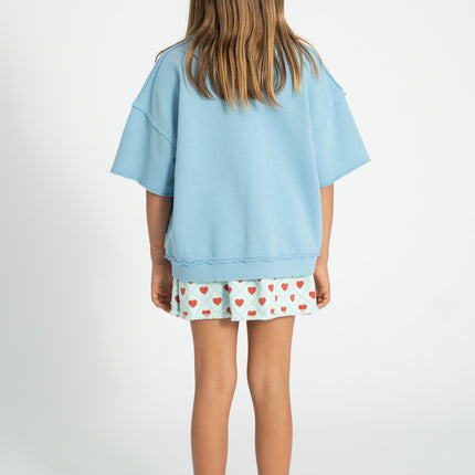 kid wearing red socks with ecru heart print