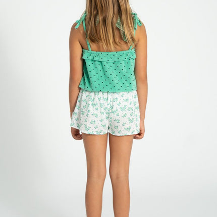 girl wearing green top with black hears allover paired with floral shorts