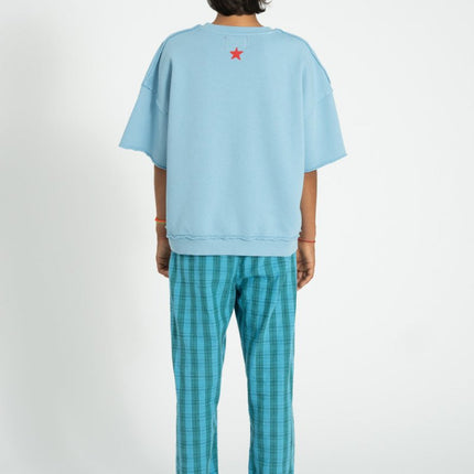 boy wearing an oversized sweatshirt paired with blue and green checkered trousers