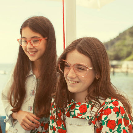 Two young girls wearing blouse with red roses print