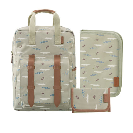 A matching backpack and small accessories set in a light beige fabric with a blue and brown beach-themed print, featuring tan faux-leather straps and trim.
