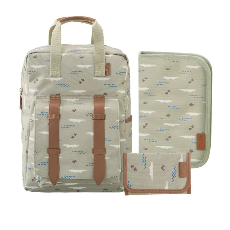 A matching backpack and small accessories set in a light beige fabric with a blue and brown beach-themed print, featuring tan faux-leather straps and trim.