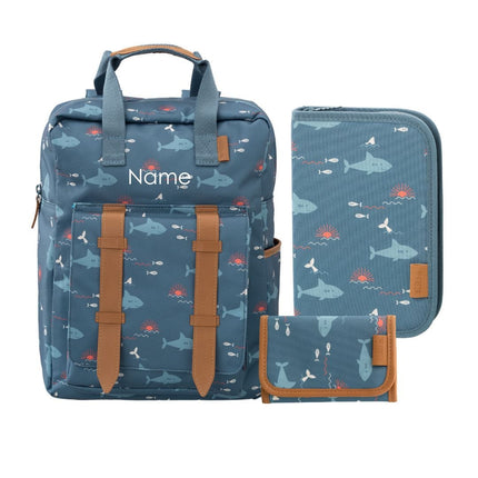 A matching three-piece personal organizer set including a backpack, a zippered pouch, and a wallet, all in a blue ocean-themed print with sharks and fish, accented with brown faux-leather trim and straps. Backpack can be personalized.
