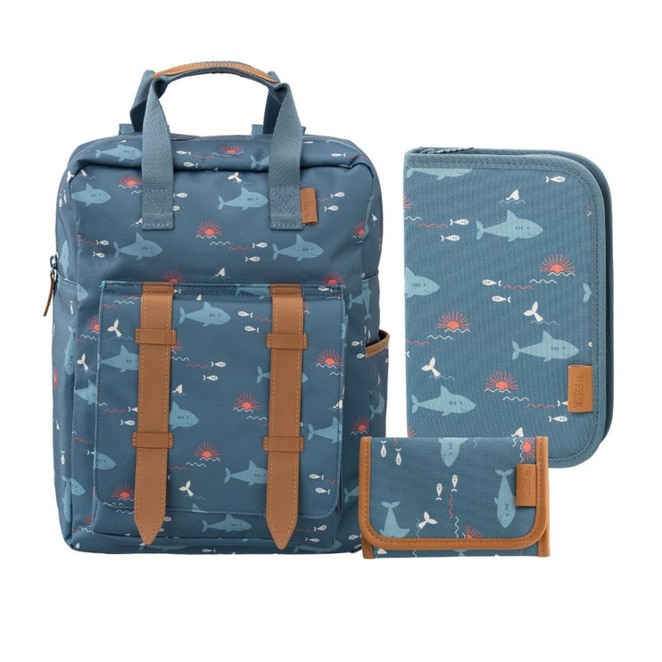 A matching three-piece school set including a backpack, a zippered sleeve, and a small pouch, all in a blue fabric with shark  print, accented with brown faux-leather trim.