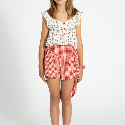 Young girl wearing a red flowers sleeveless blouse 