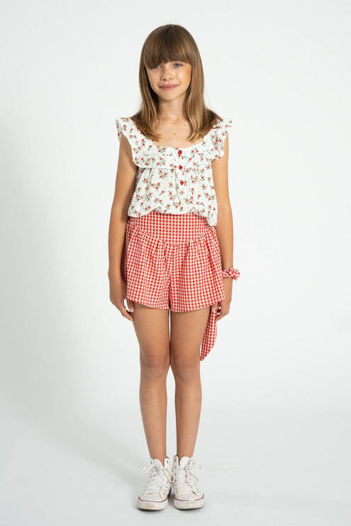 Young girl wearing a red flowers sleeveless blouse 