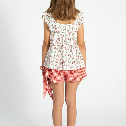 Young girl wearing a blouse with red floral pattern 