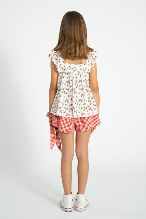 Young girl wearing a blouse with red floral pattern 
