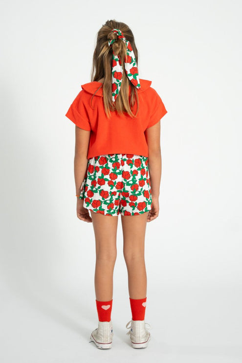 kid wearing shorts with red roses pattern