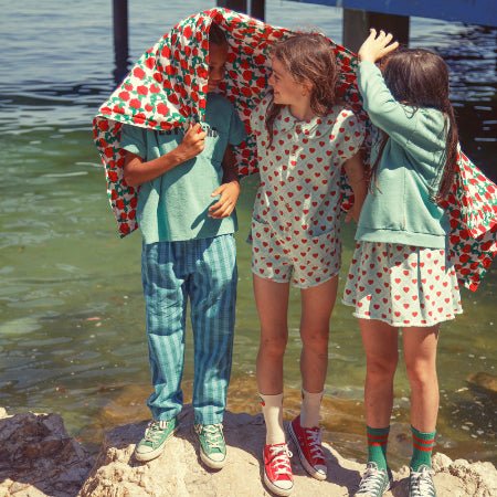 Girl wearing light blue shot sleeved jumpsuit with red hearts all over