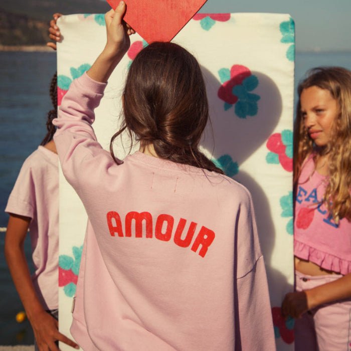Backview of girl wearing lilac sweatshirt with Amour print