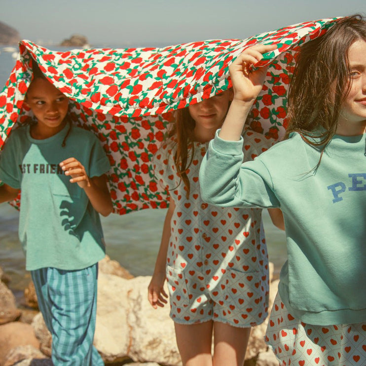 Girl wearing turquoise sweatshirt wirh peace print