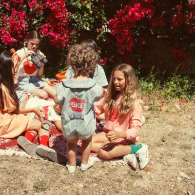 Girl wearing light pink sweatshirt  with collar and strawberry print