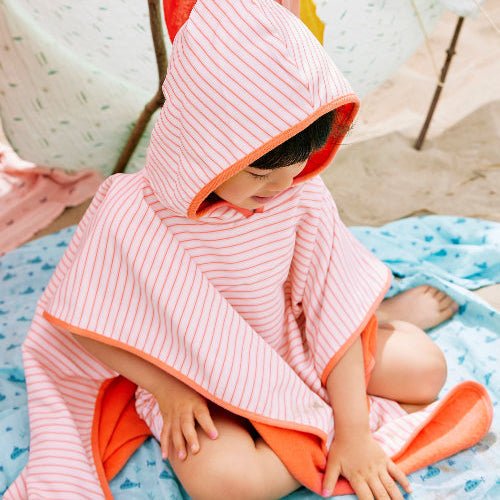 Girl wearing stripped cream and peach Swim Poncho
