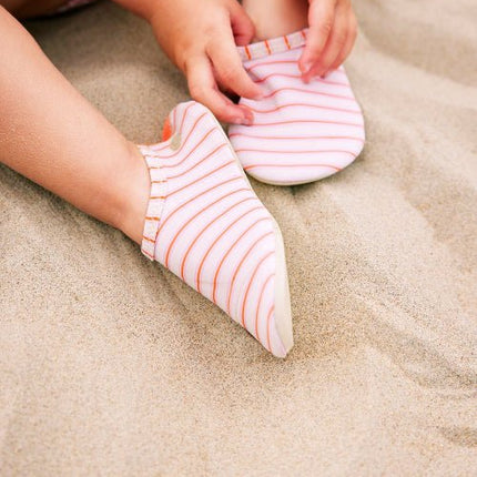 Baby girl wearing stripped cream and peach Swim shoes 