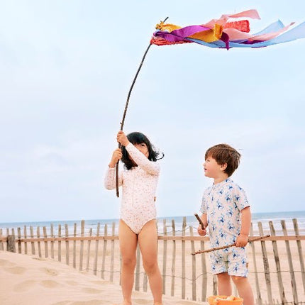 Girl wearing cream longsleeves swim suit with Butterflies print featuring a boy wearing a cream swim suit with blue monkey prints