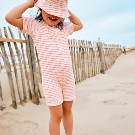 Cheerful girl wearing Striped cream and peach Swim suit, bucket hat & Swim Shoes 