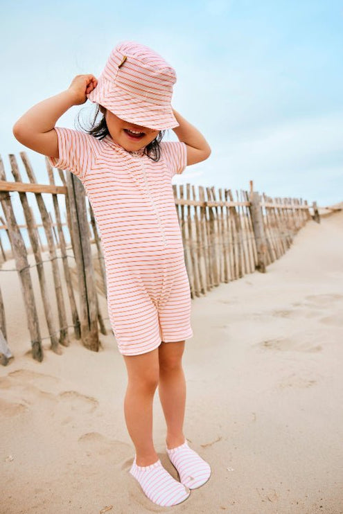 Cheerful girl wearing Striped cream and peach Swim suit, bucket hat & Swim Shoes 