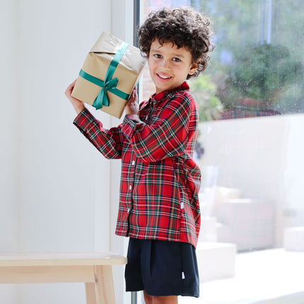 Boy wearing long sleeved tartan shirt