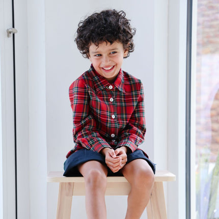 Boy wearing long sleeved tartan shirt