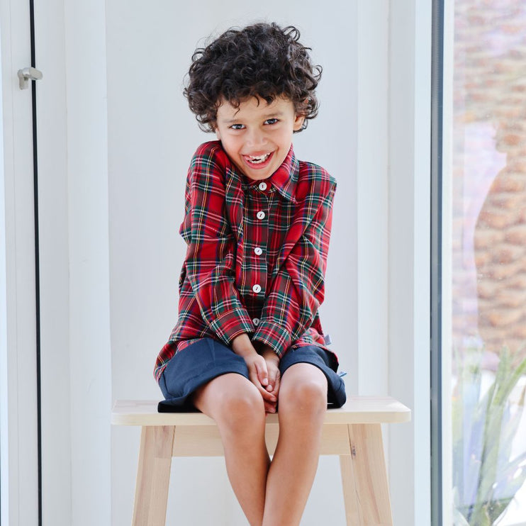 Boy wearing long sleeved tartan shirt