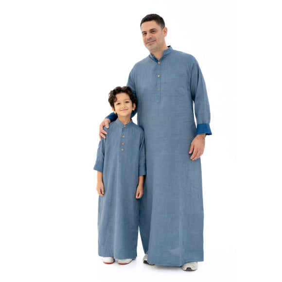 Father and child wearing matching blue traditional outfits on a white background