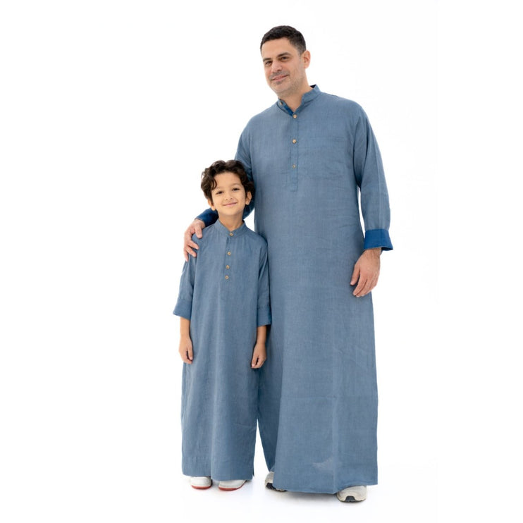 Father and child wearing matching blue traditional outfits on a white background