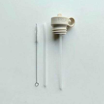 A beige replacement lid for a Nordic thermos bottle, displayed alongside a foldable drinking straw and a cleaning brush, all placed on a light background.
