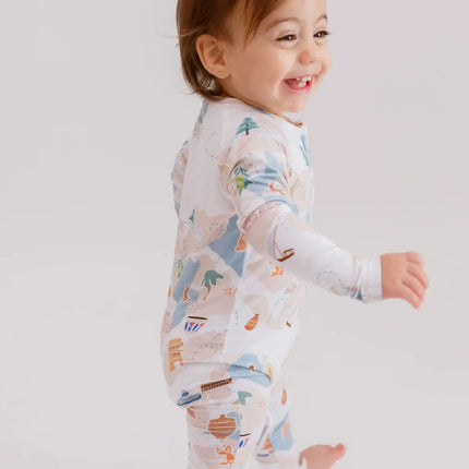 Child wearing a patterned onesie on a plain background
