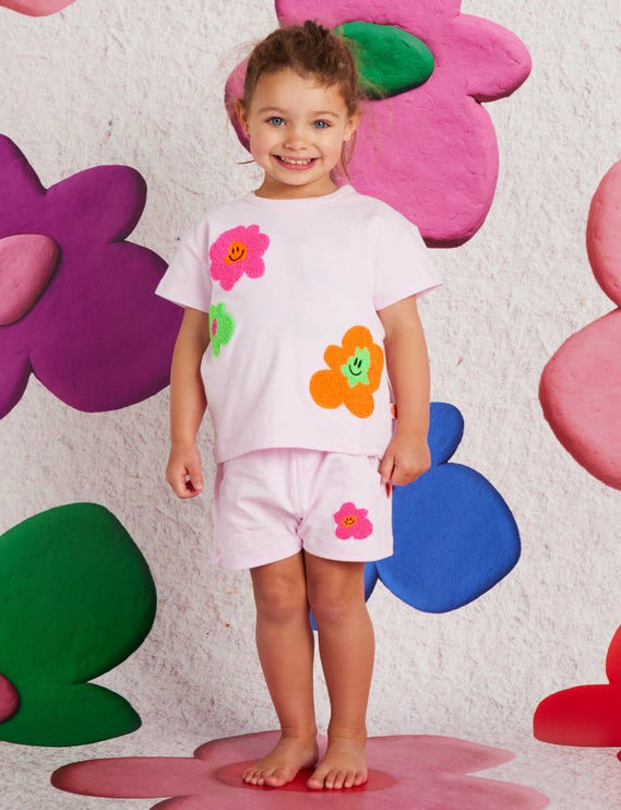 child wearing a tshirt with flower print and matching shorts