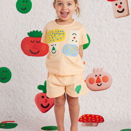 kid wearing a peach short with cute broccoli design