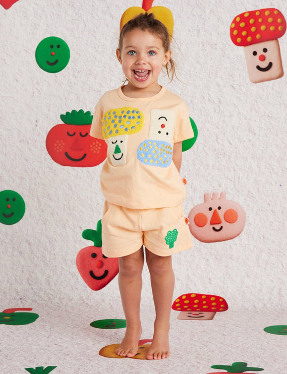 kid wearing a peach short with cute broccoli design
