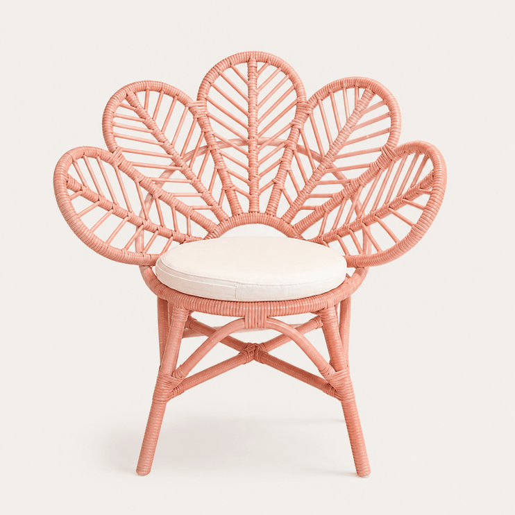 Pink wicker chair with a white cushion on a light gray background