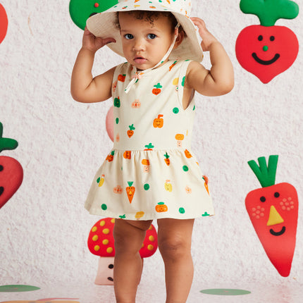 Child wearing a singlet dress with veggie print design